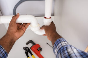 A man fixing a blocked drain