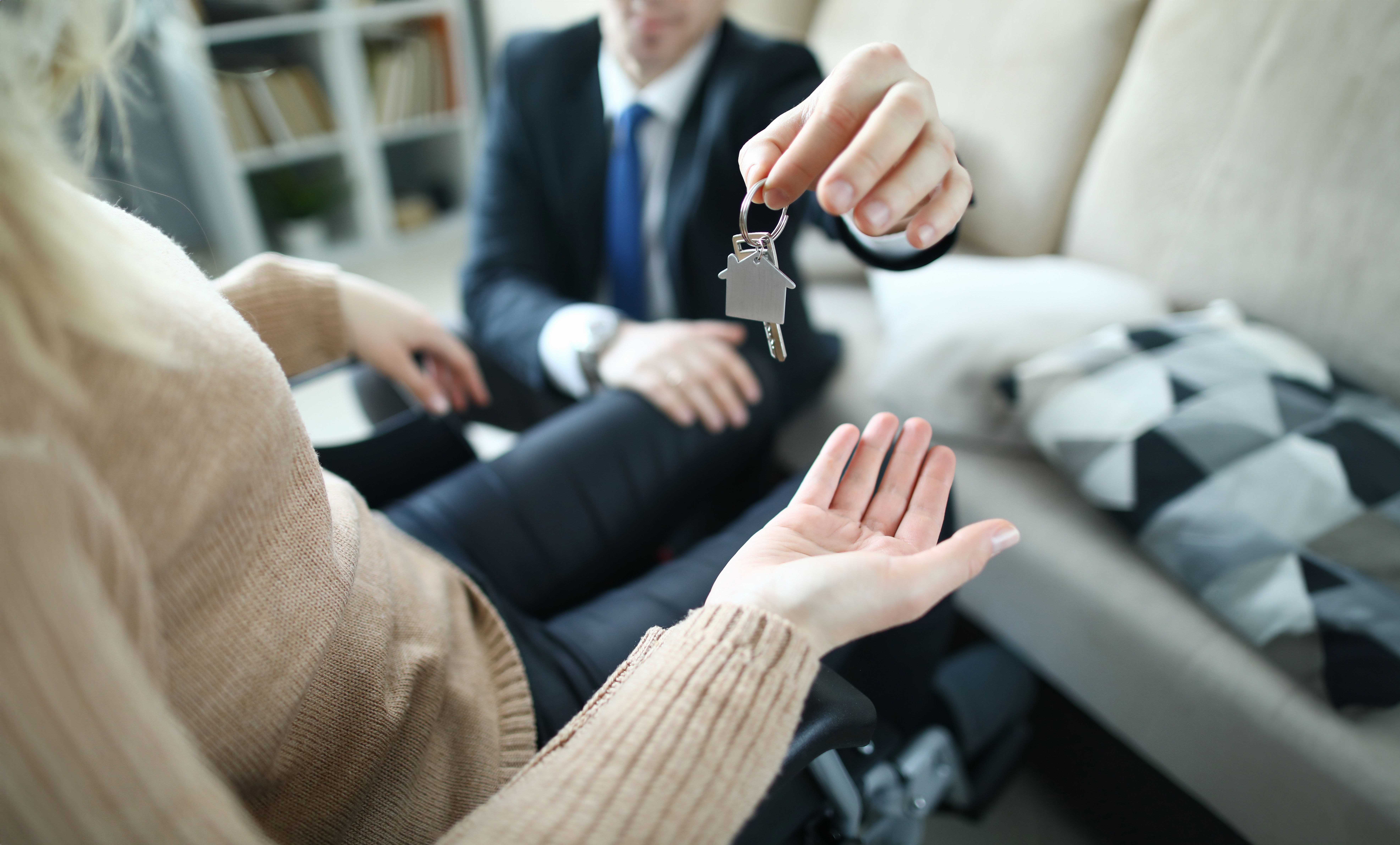An image of a disabled tenant being handed a key